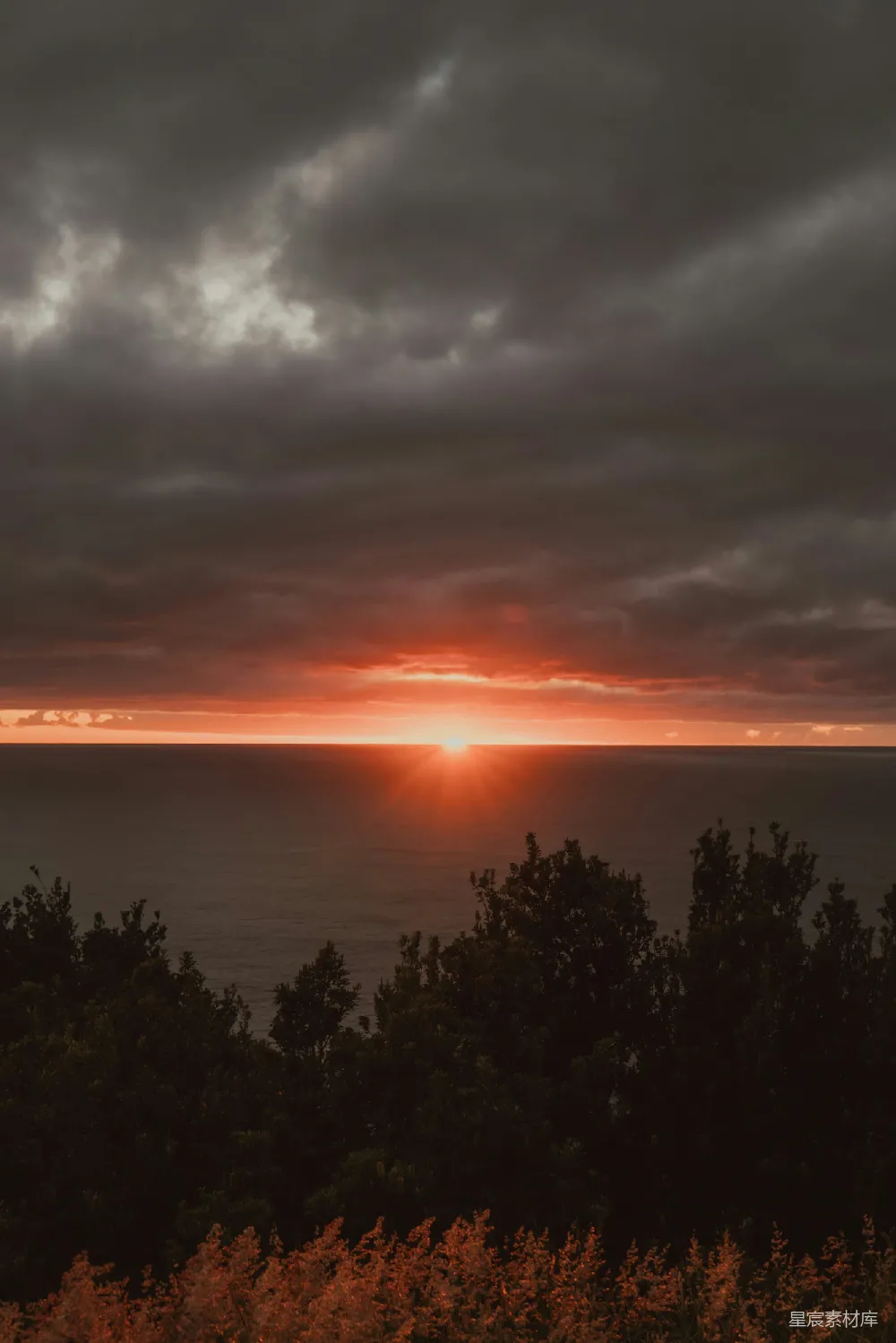 高清摄影  夕阳映照海面，天空阴沉，乌云密布。