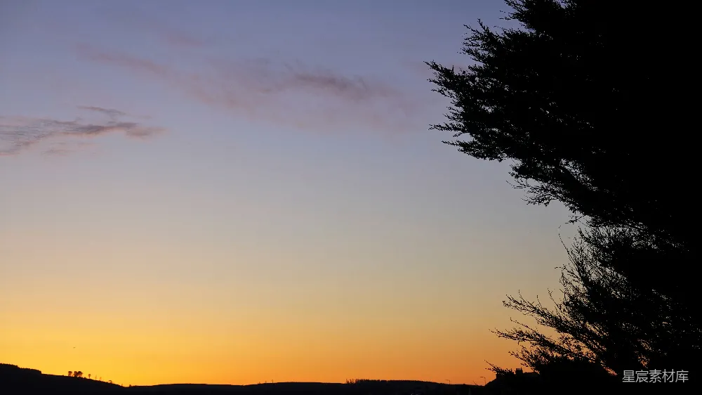 高清摄影  夕阳西下，天空中树木和山峦的剪影