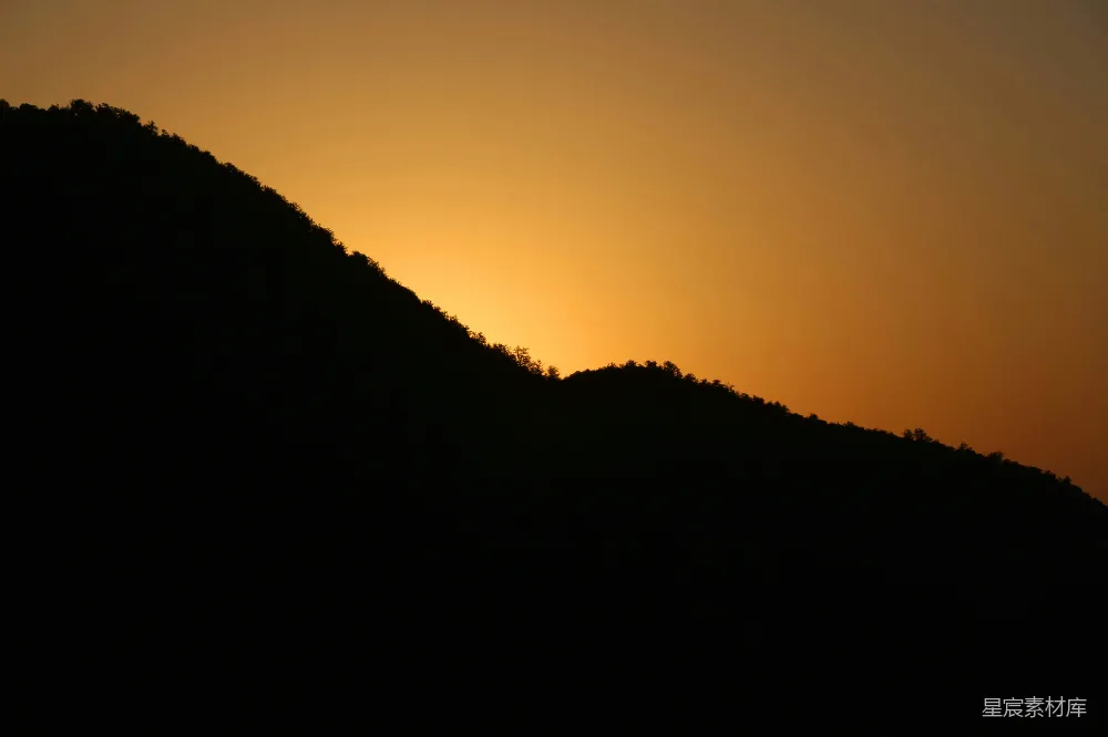 高清摄影  山的剪影映衬在温暖的夕阳天空下