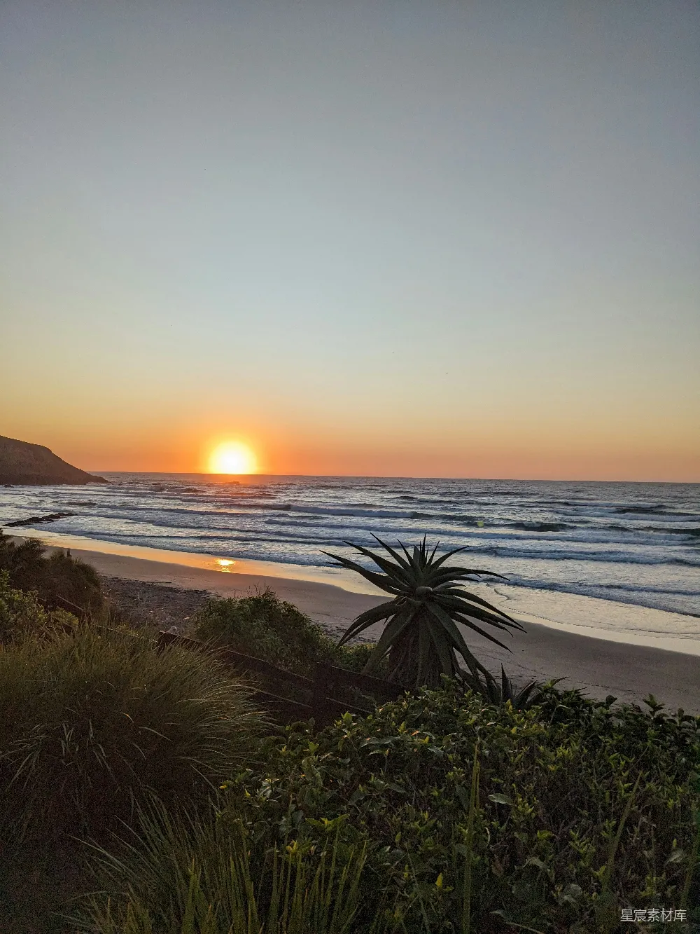 高清摄影 自然 夕阳正在海面上落下，照在沙滩上。