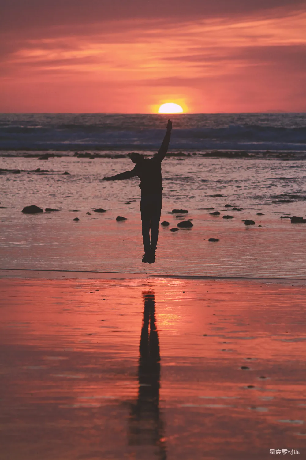 高清摄影  穿黑色连衣裙的女人站在海滩上，夕阳西下。