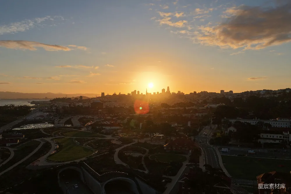 高清摄影  夕阳照耀在城市天际线上，云层漂浮其中。