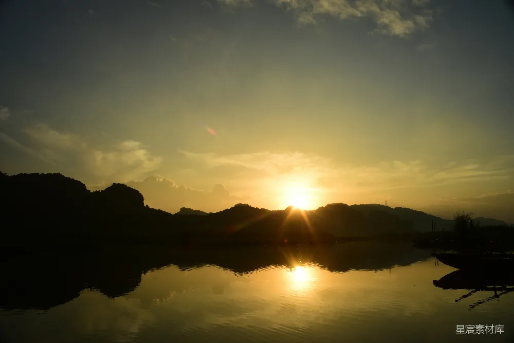 高清摄影  湖面平静，夕阳映照，远处山影轮廓清晰。