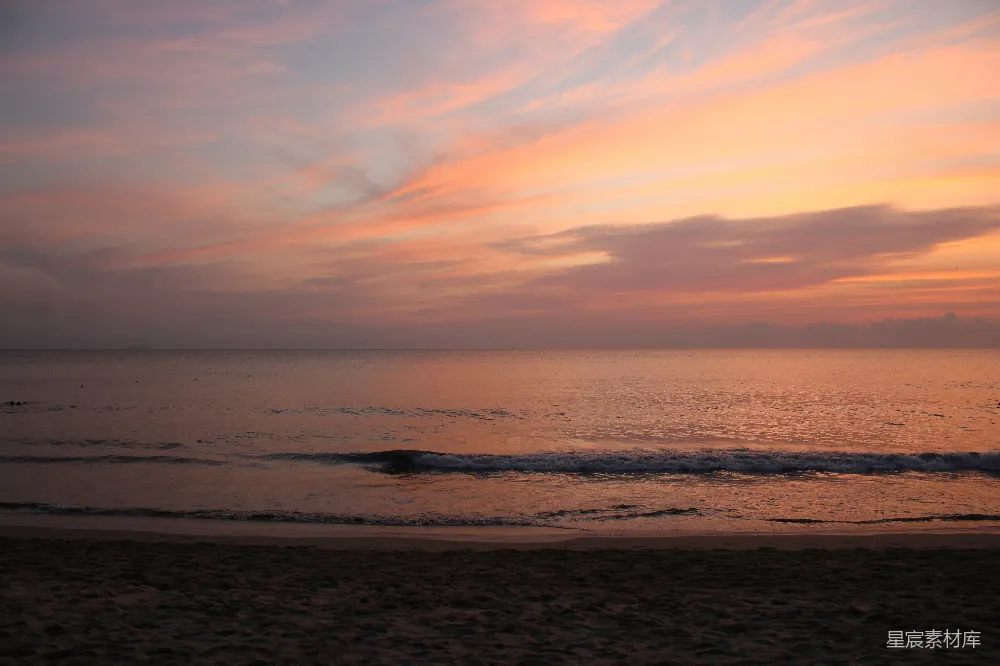 高清摄影  夕阳西下，海浪轻柔地拍打着沙滩。