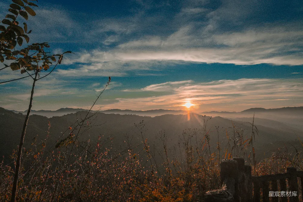 高清摄影  雾蒙蒙的山峦上空升起朝霞，天空中有戏剧性的云彩。