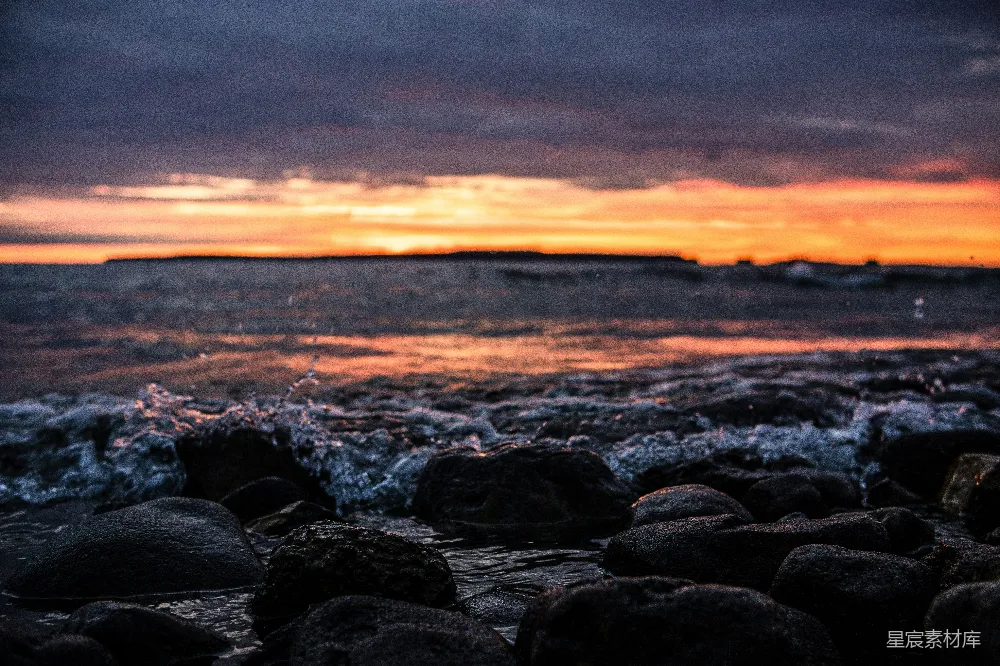 高清摄影  夕阳西下，海浪拍打着岩石海岸。