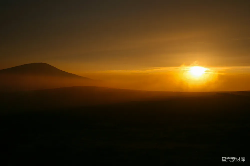 高清摄影  金色的夕阳在雾蒙蒙的山峰后缓缓落下。
