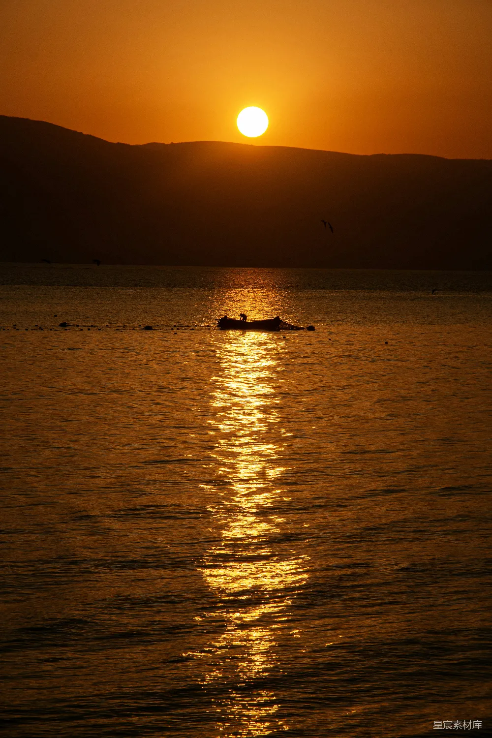高清摄影  在夕阳下，一艘小船漂浮在海洋上。