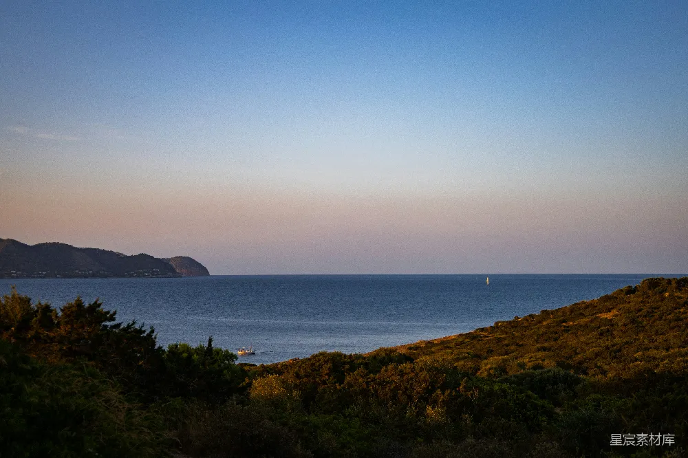 高清摄影  日落时分，海景如画，远处的帆船映衬在天边。