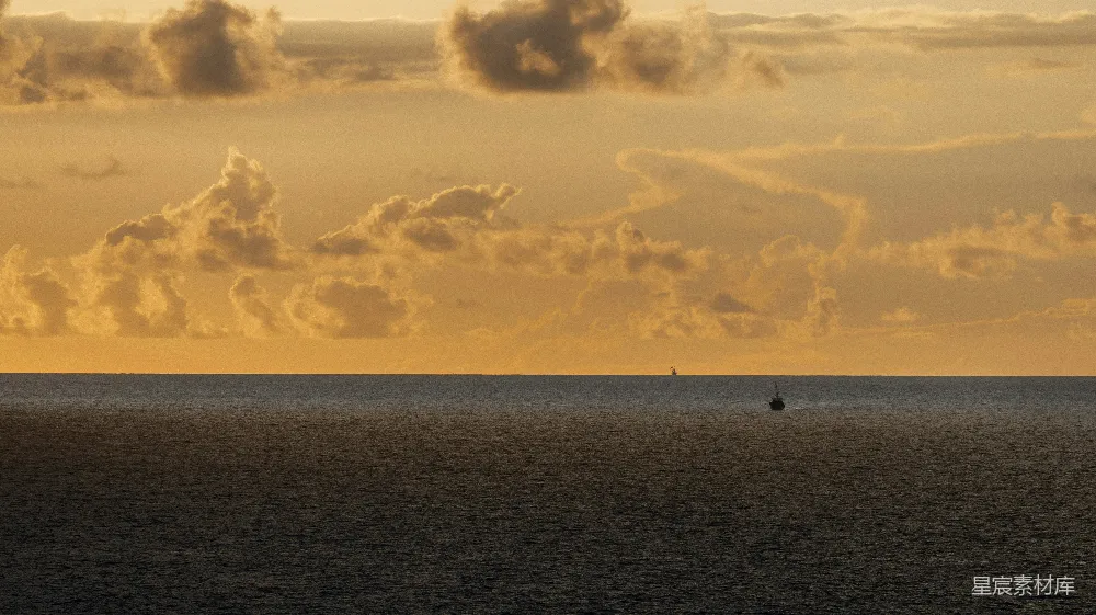 高清摄影  金色的夕阳云彩漂浮在平静的海洋地平线上