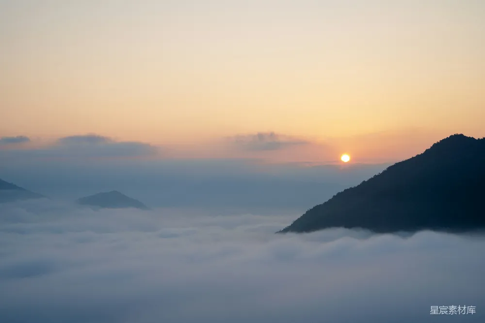 高清摄影  云海中旭日初升，山峰隐约可见。