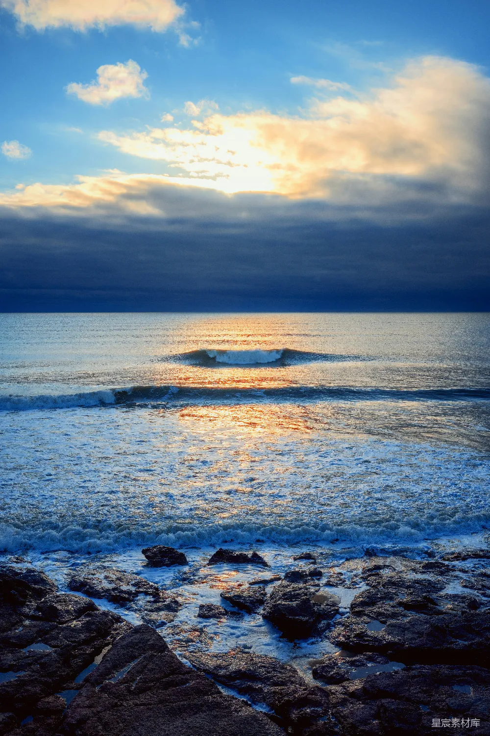 高清摄影  海浪拍打着岩石海岸，夕阳西下。