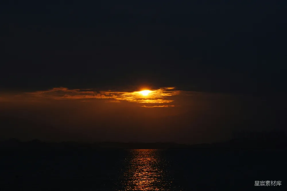 高清摄影  夕阳正缓缓落下，倒映在水面上。
