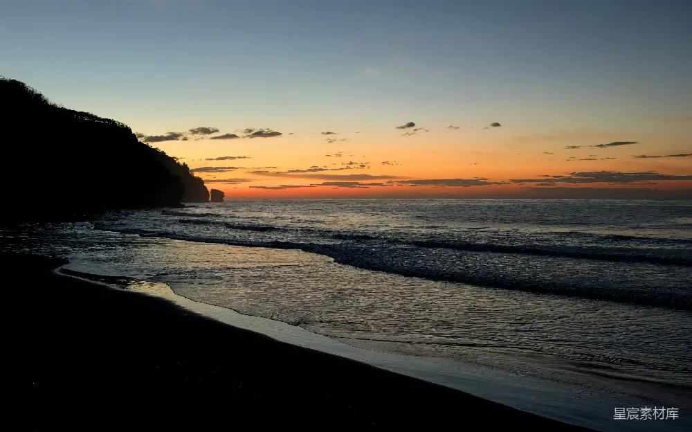高清摄影  夕阳照耀着海滩，波浪翻滚。