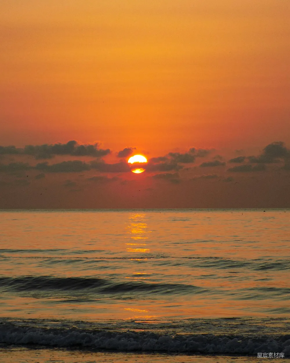 高清摄影  在多云的日子里，夕阳正从海平面上落下。