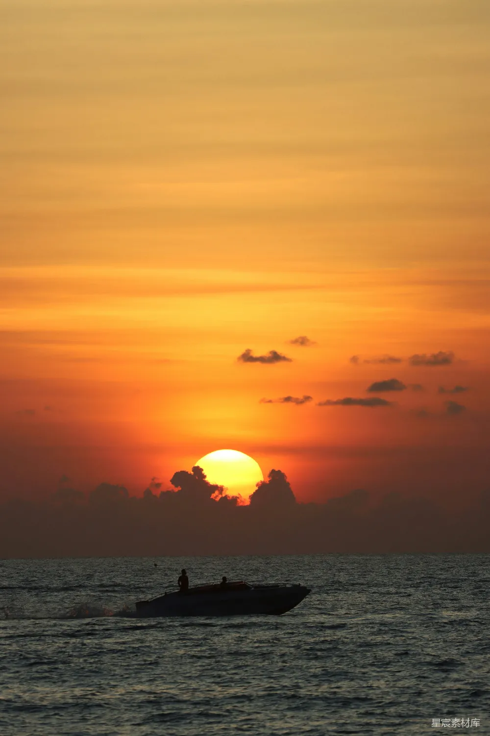 高清摄影  一艘船在海洋中，夕阳在背景中落下