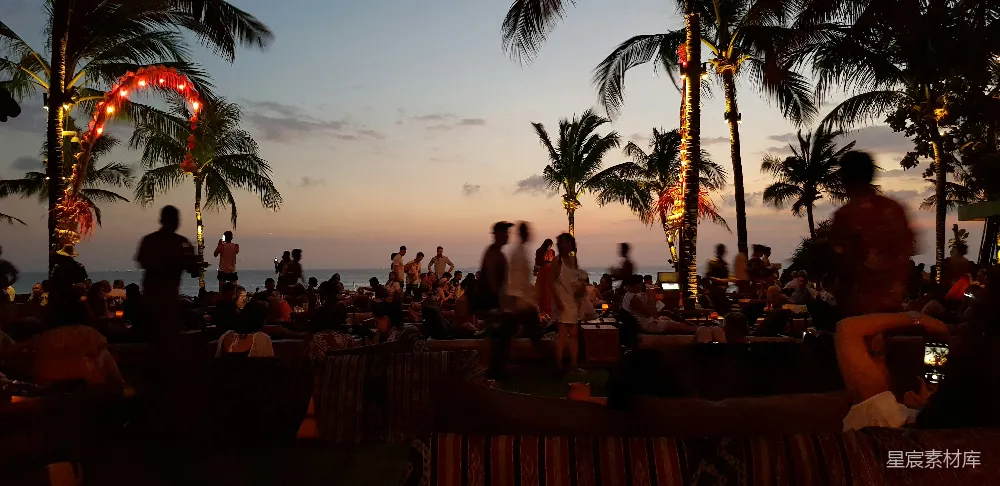 高清摄影 自然 一群人在日落时分坐在海滩上。