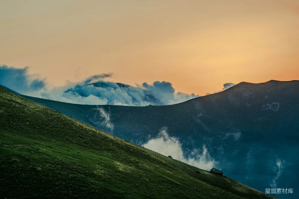 高清摄影  日落时，山峦与云雾相接。