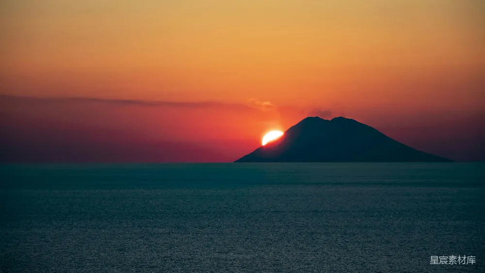 高清摄影  太阳正在海洋中一个小岛的上方落下。