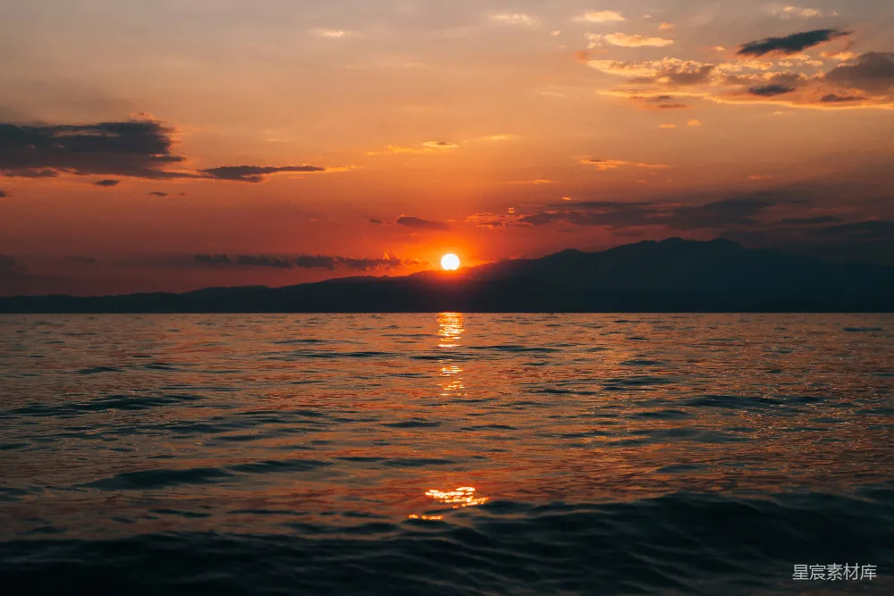 高清摄影  夕阳正缓缓地垂落在水面上。