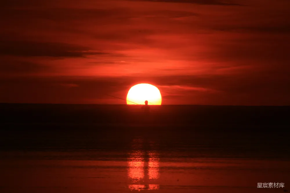 高清摄影  在多云的日子里，太阳正缓缓落向海平面上方。