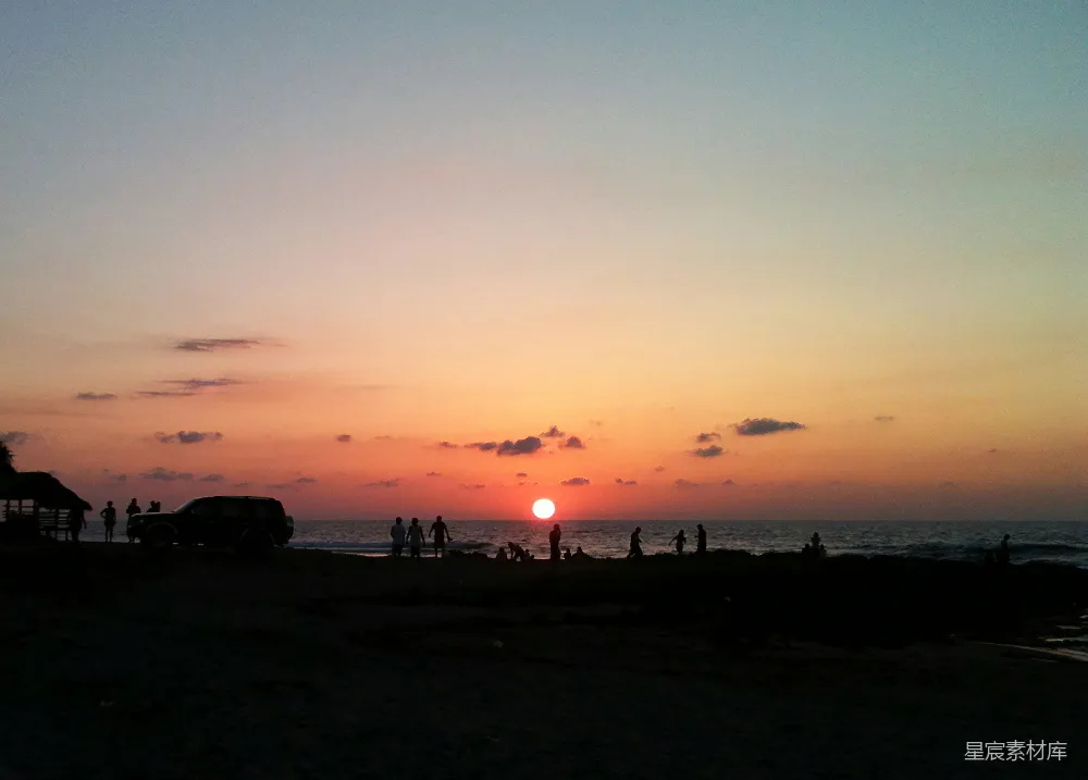 高清摄影  夕阳映照在海面上，人们在剪影中。