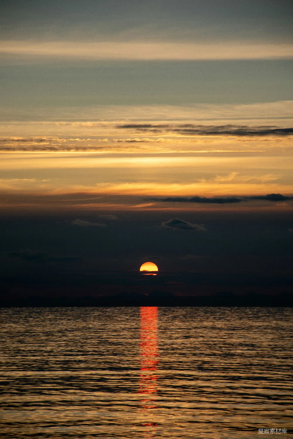 高清摄影  夕阳正缓缓落下，洒在海面上。