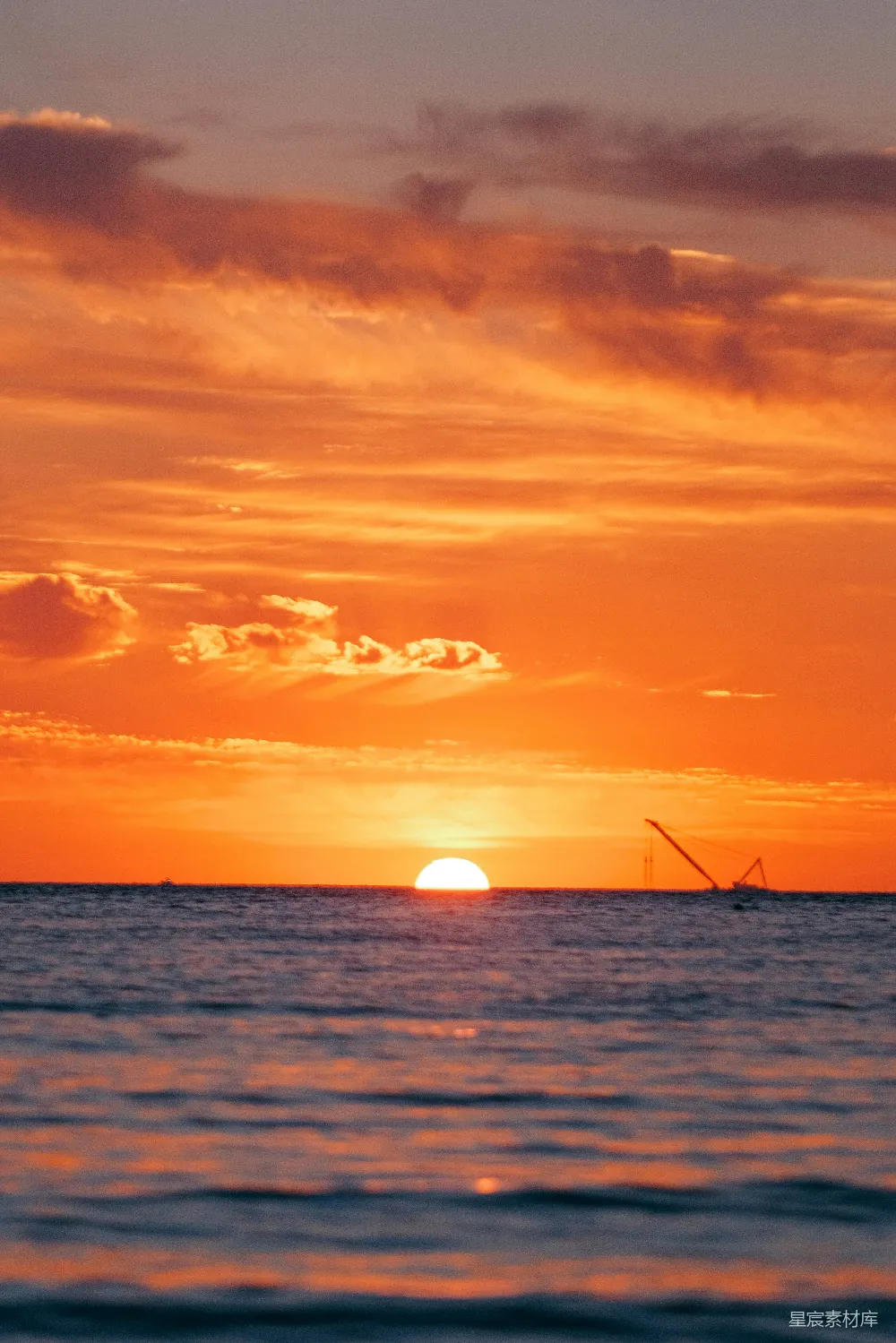高清摄影  夕阳正落下，海面上有一艘船。