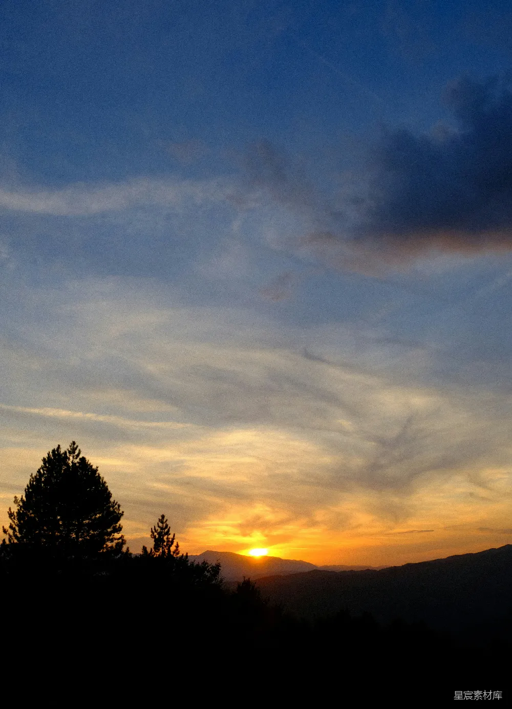 高清摄影  夕阳西下，山峦和树木笼罩在余晖中。