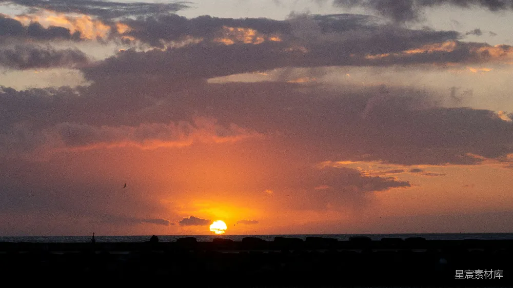 高清摄影  夕阳正缓缓地沉落在海洋的地平线上。
