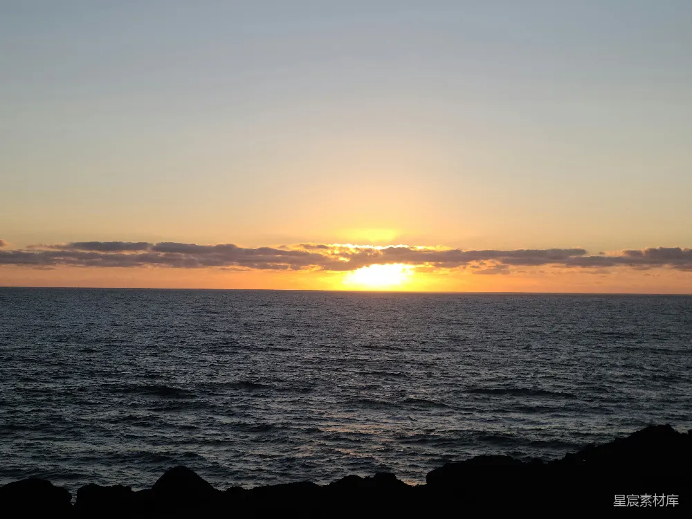 高清摄影  夕阳映照在海面上，背景是夕阳海滩。