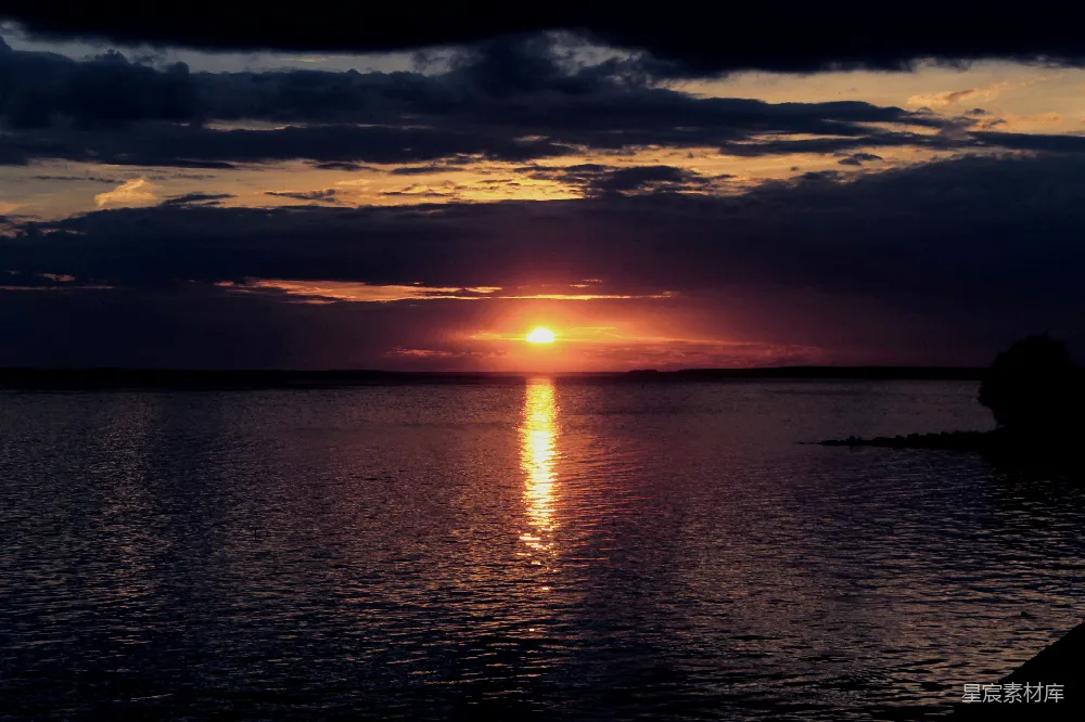 高清摄影  一片广阔的水域，背景中有一抹夕阳。