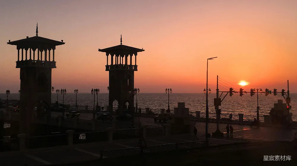高清摄影  夕阳正照耀在海面上，前景中有一座码头。