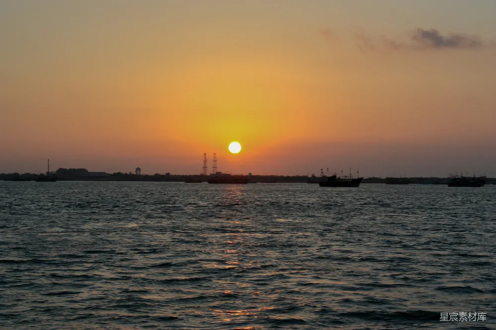 高清摄影 旅行 自然 壁纸 夕阳照耀着一片水域，远处有几艘船。