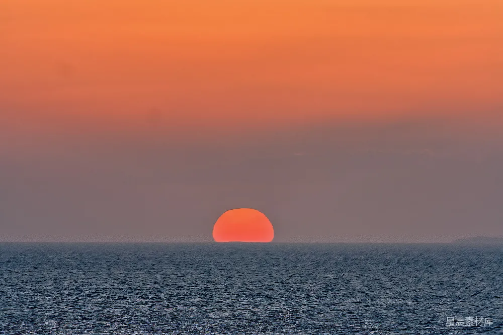 高清摄影  在多云的日子里，太阳正从海洋上落下。
