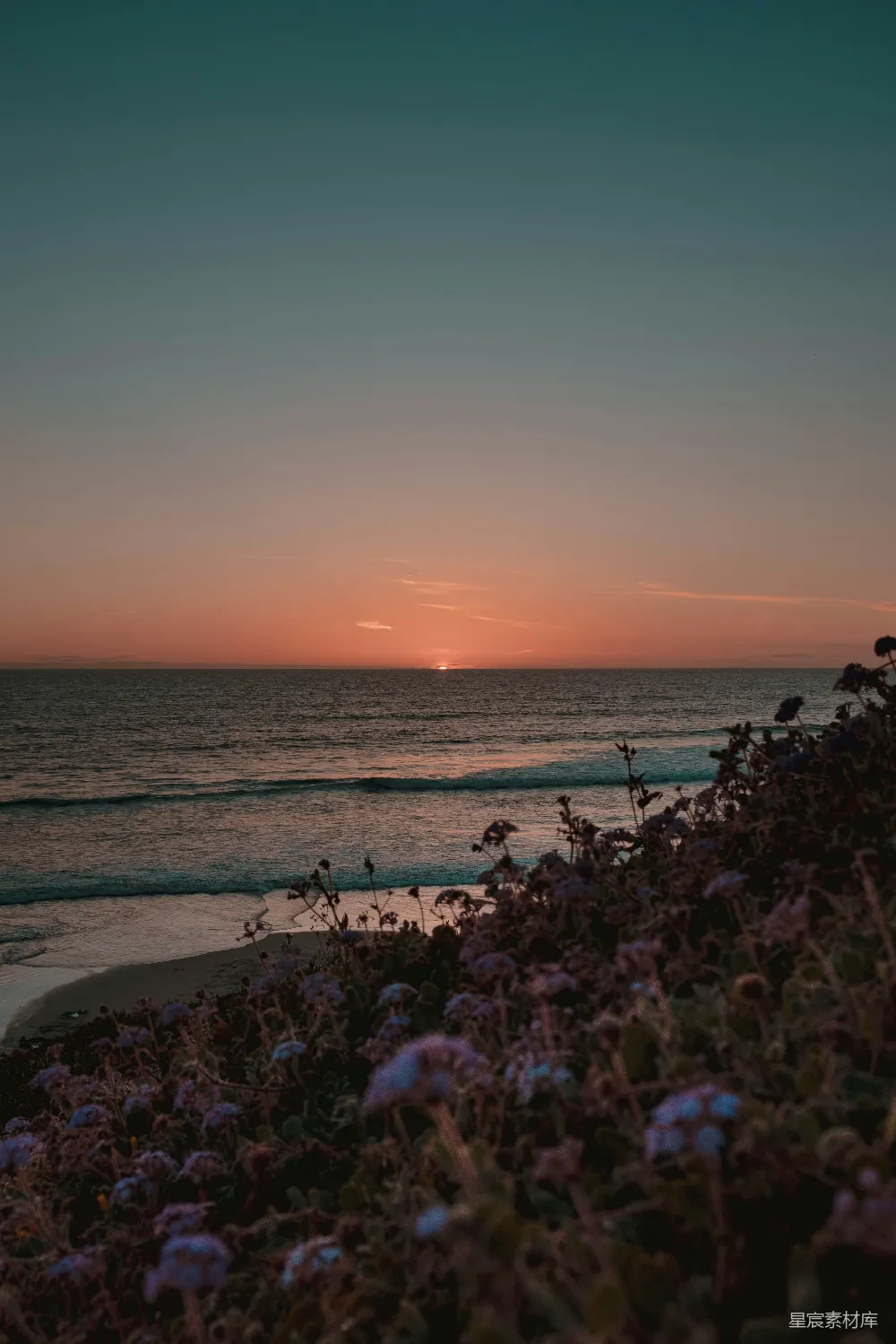 高清摄影  夕阳正挂在海洋上方的海滩上。