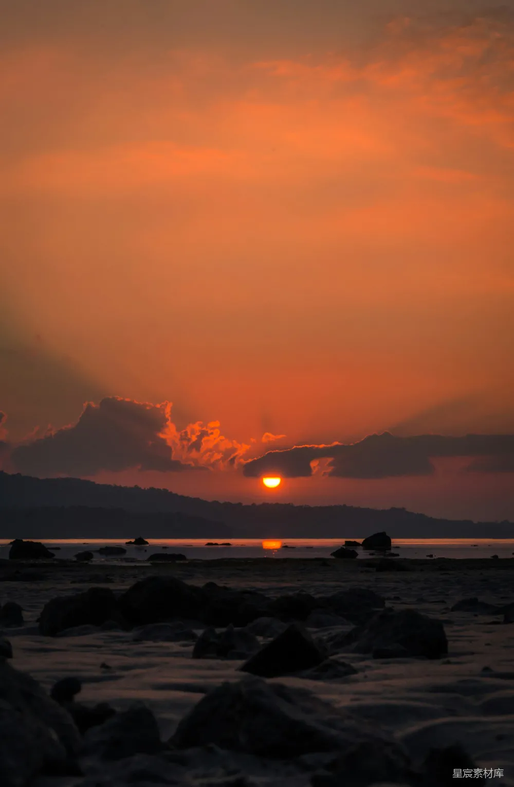 高清摄影  夕阳西下，落日余晖洒在岩石沙滩上