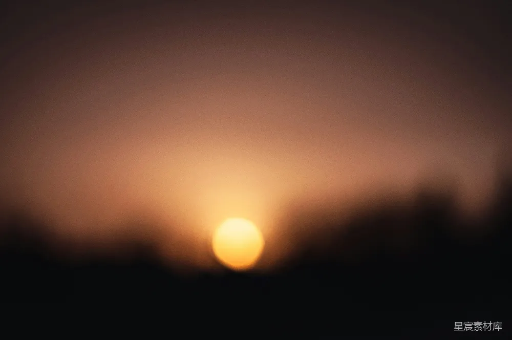 高清摄影  一张模糊的夕阳照在天空中的照片