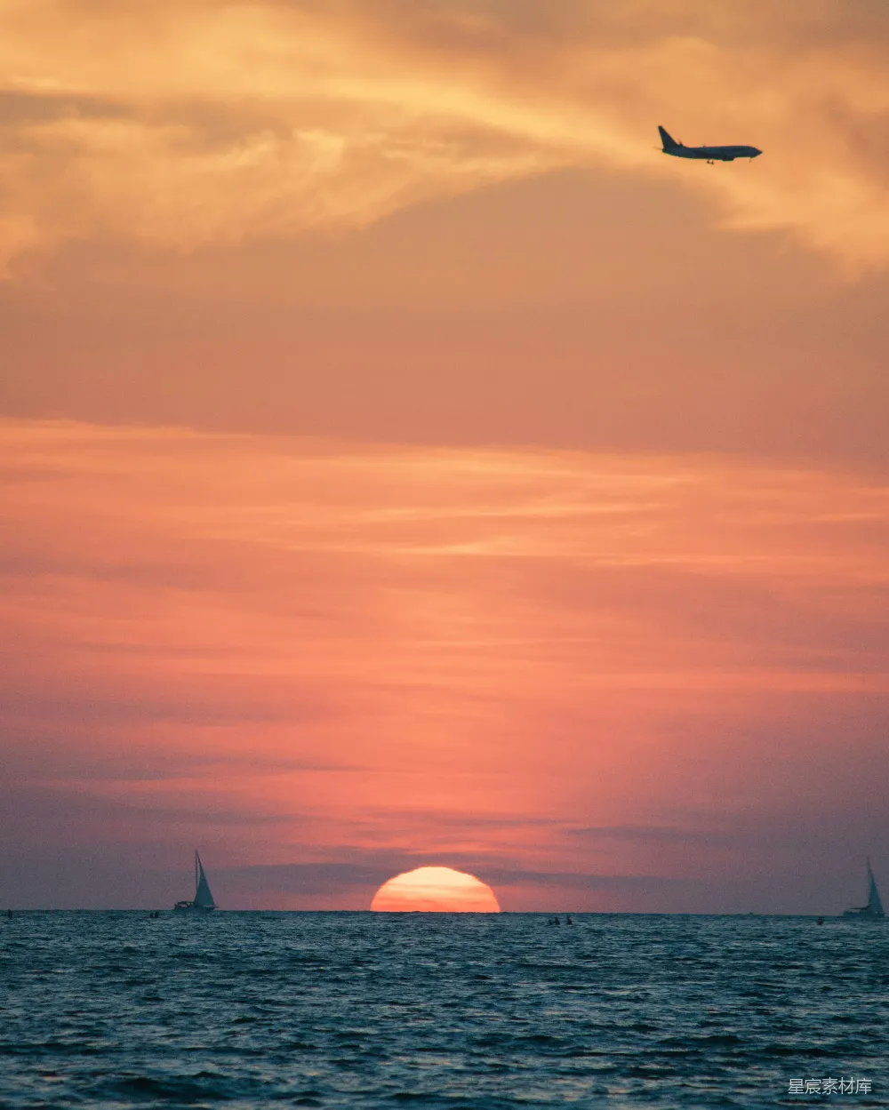 高清摄影  一架飞机在夕阳下飞越海洋。