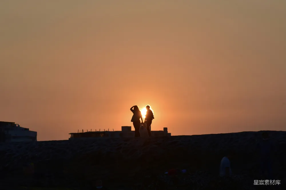 高清摄影  夕阳下海滩上的人影