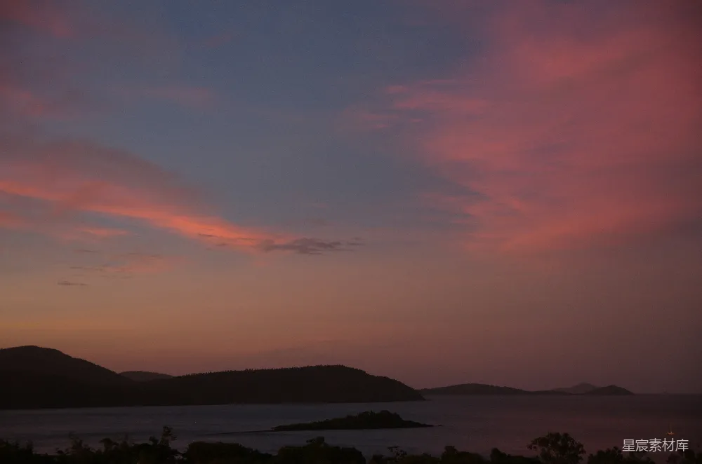 高清摄影  夕阳映照在水面上，背景是连绵的山脉。