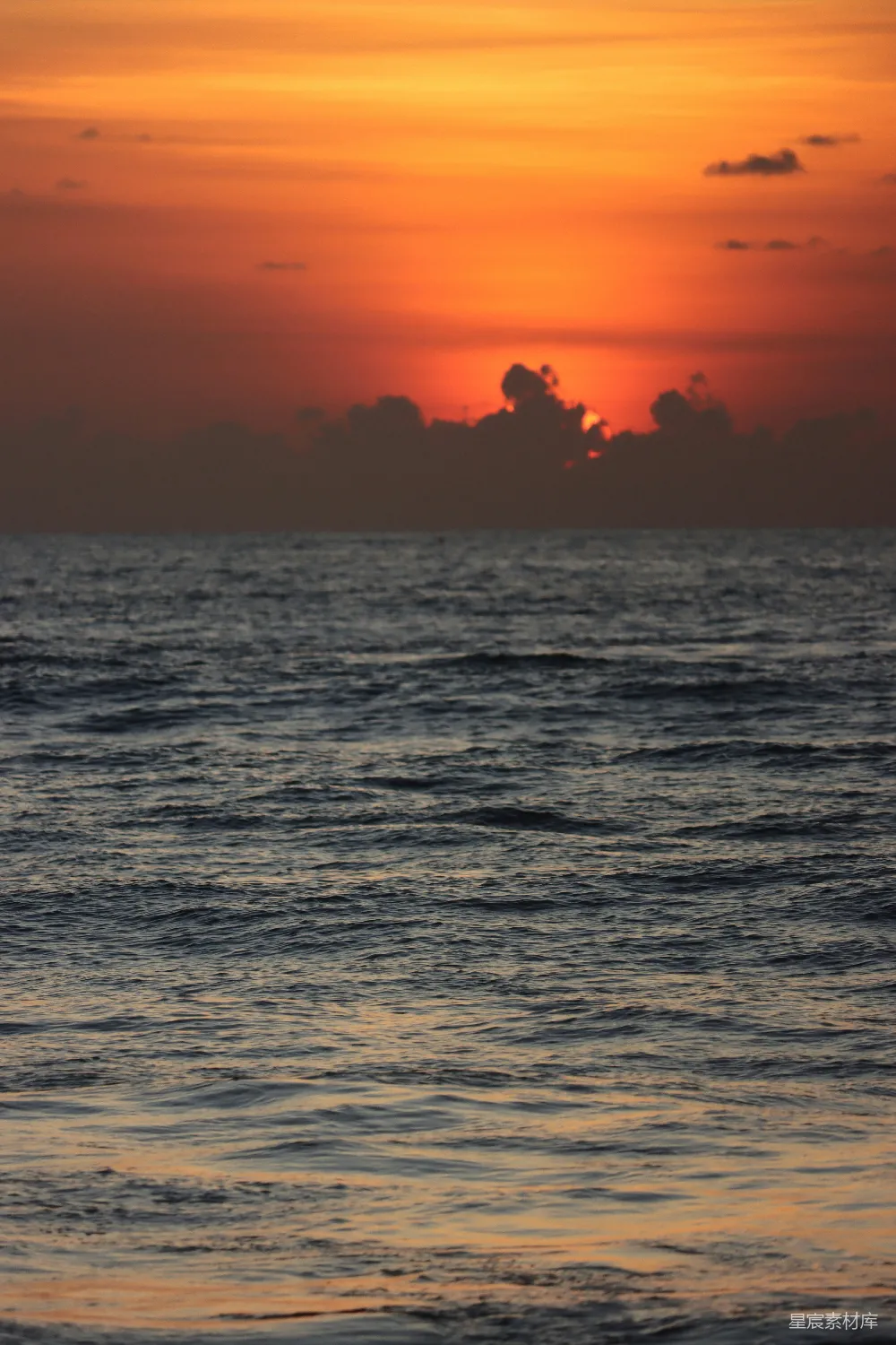 高清摄影  夕阳正在海洋上落下，水面上有一艘小船。