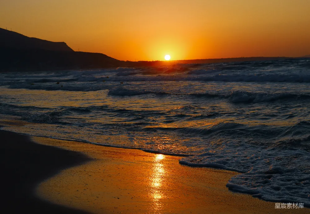 高清摄影  夕阳正在海滩的水面上落下。