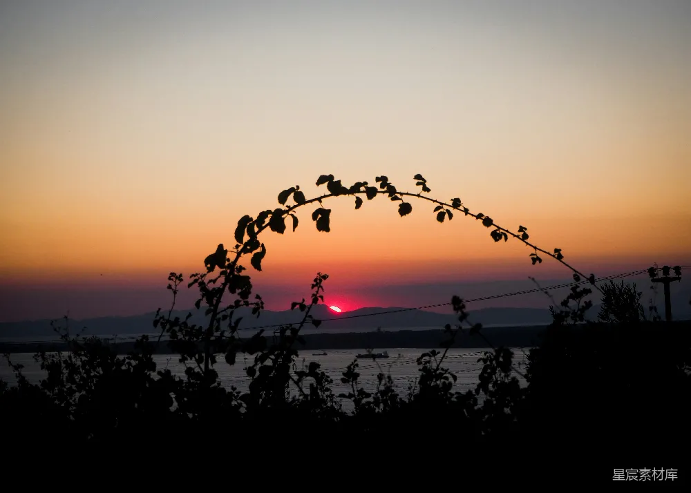 高清摄影  夕阳正落下在一片水域之上。