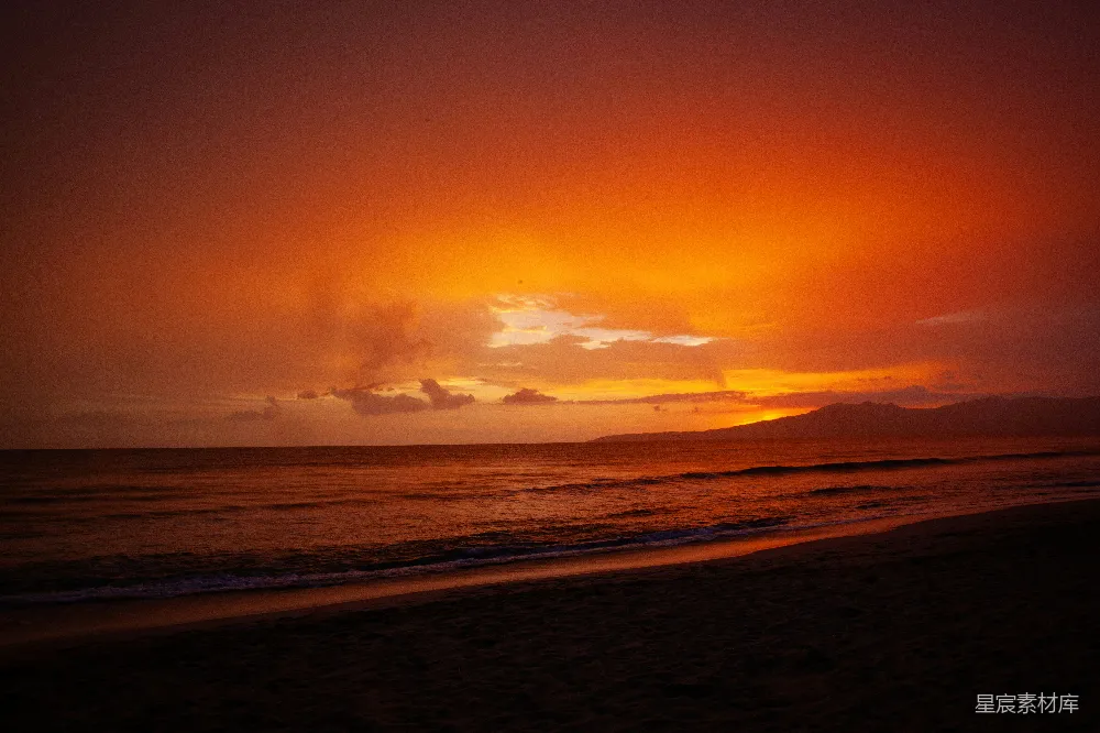 高清摄影  夕阳正从海上升起，海滩上。