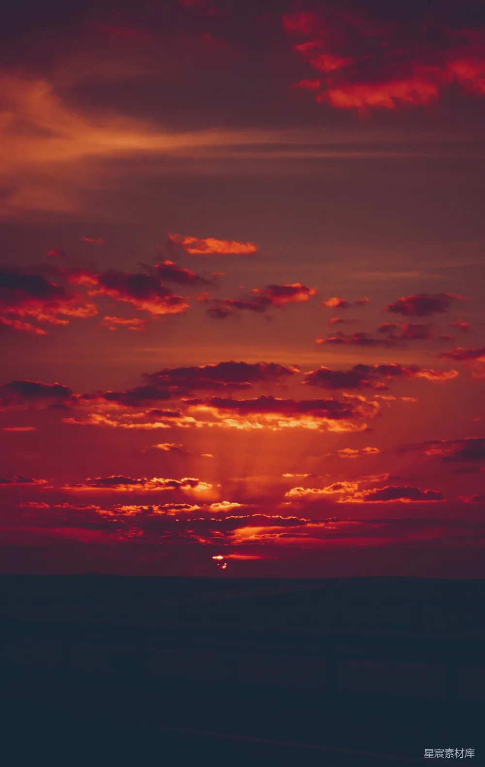 高清摄影  夕阳正缓缓落向水面上方的地平线。