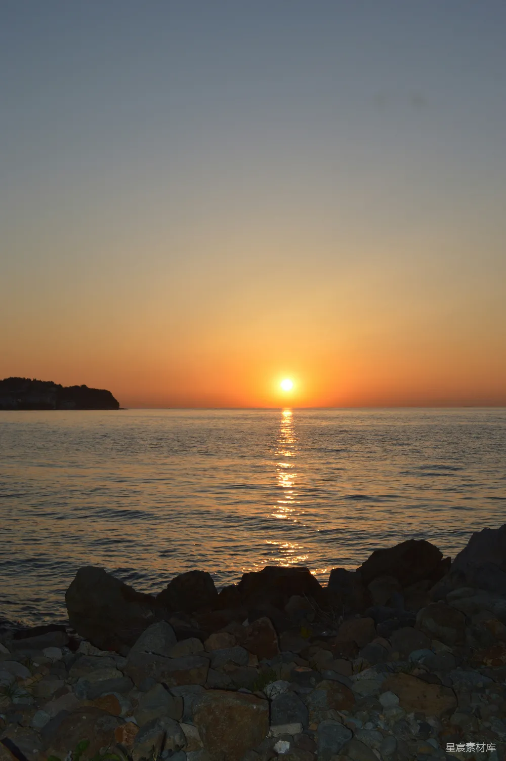 高清摄影  岩石海滩上，夕阳正在落下。