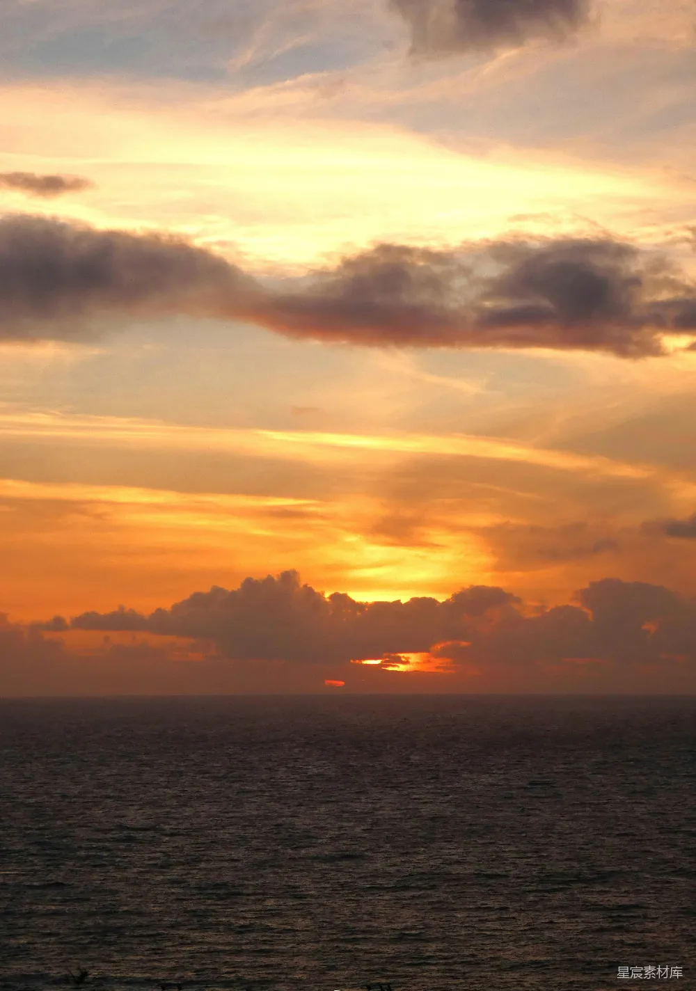 高清摄影  一片广阔的水域，背景中是夕阳的景色。