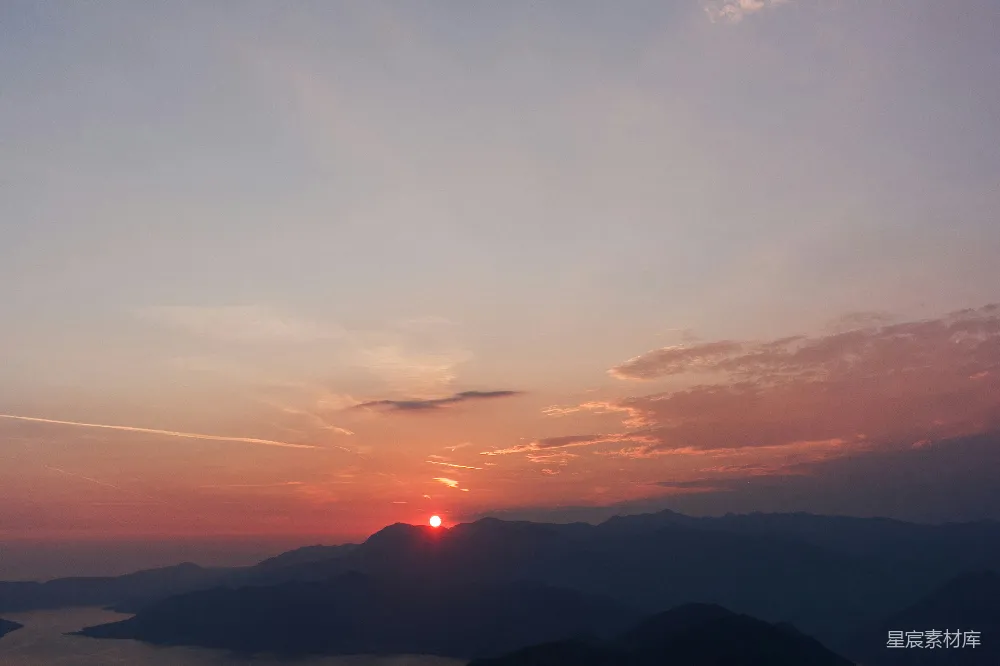 高清摄影  日落时分，山脉上空的太阳正在落下。