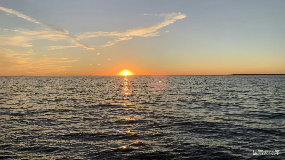 高清摄影  太阳正落向大海，远处有一座小岛。